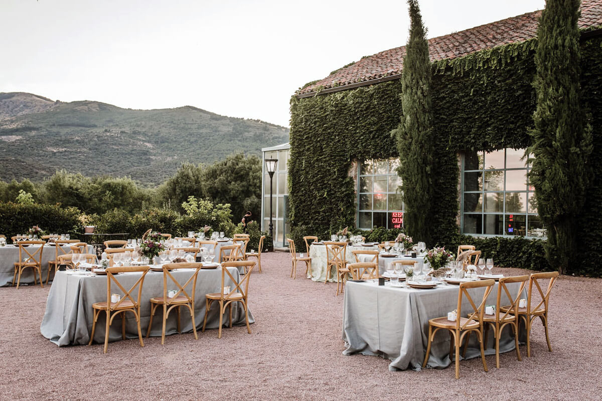 Mesas y sillas para el banquete de una boda al aire libre en Madrid